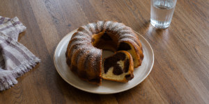 A traditional Czech marble babovka bundt cake dusted with powdered sugar on a wooden table