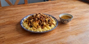 Authentic Moroccan Couscous Tfaya topped with caramelized onions, raisins, and toasted almonds