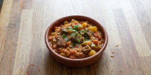 Traditional Bulgarian gyuvech with beef, rice, potatoes, tomatoes and peppers