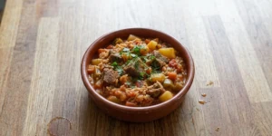 Traditional Bulgarian gyuvech with beef, rice, potatoes, tomatoes and peppers