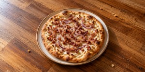Hungarian kenyérlángos with smoked bacon and red onion