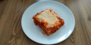 A slice of lasagne showing the layers of meat and sauce