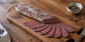 Traditional Bulgarian lukanka with flattened shape and marbled slices