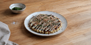 Traditional Osaka-style okonomiyaki with pork belly, okonomiyaki sauce, mayonnaise, aonori and bonito flakes