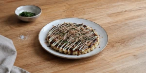 Traditional Osaka-style okonomiyaki with pork belly, okonomiyaki sauce, mayonnaise, aonori and bonito flakes