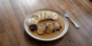 Svíčková served with bread dumplings and cranberry sauce