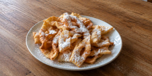 Traditional Lithuanian žagarėliai angel wing pastries dusted with powdered sugar