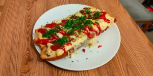Authentic Polish Zapiekanka street food with melted cheese and ketchup